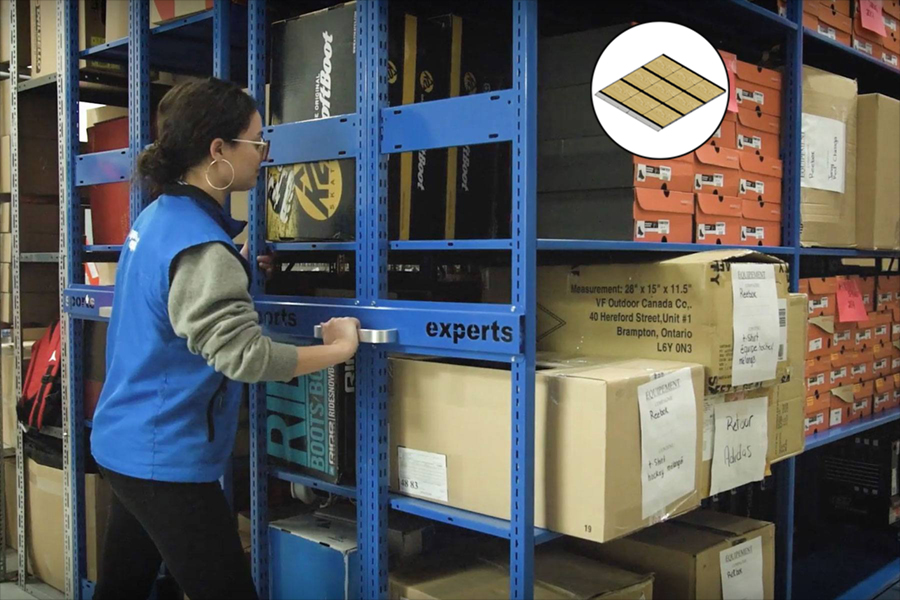 Empleado utilizando un sistema de estanter&#237;as m&#243;viles Montel azul para almacenar art&#237;culos y cajas.