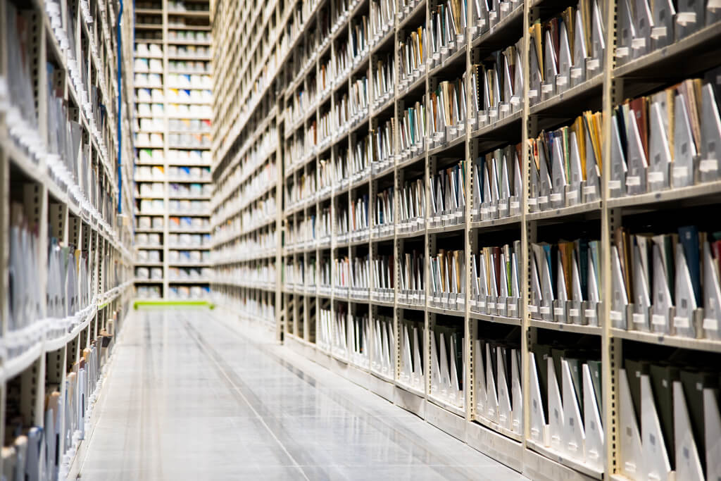 Longue rang&#233;e d&#39;&#233;tag&#232;res de stockage avec des fichiers, illustrant un syst&#232;me de rangement efficace.