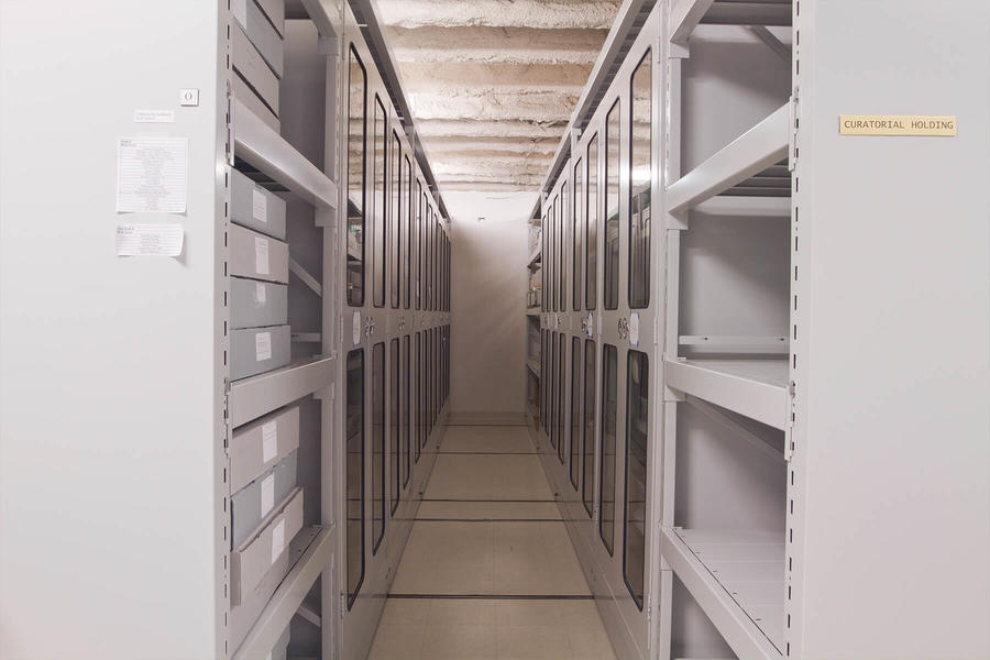Couloir &#233;troit entre des armoires de rangement &#224; portes vitr&#233;es.