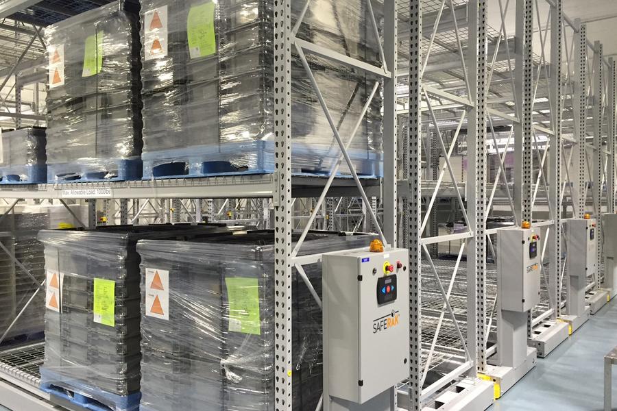 Estantes de almacenamiento en almac&#233;n con palets de productos empaquetados.