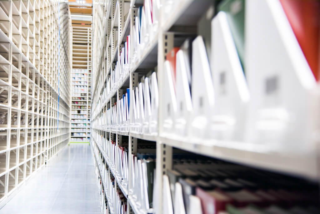 &#201;tag&#232;res blanches remplies de documents, illustrant un environnement de stockage organis&#233;.