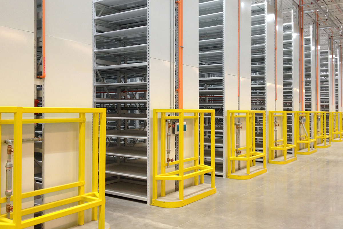 Syst&#232;me de rayonnage mobile avec barri&#232;res de s&#233;curit&#233; jaunes, garantissant un stockage s&#251;r et accessible.