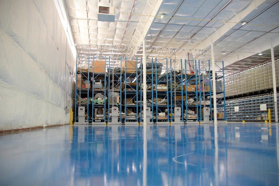Almac&#233;n con estanter&#237;as m&#243;viles y suelo azul brillante