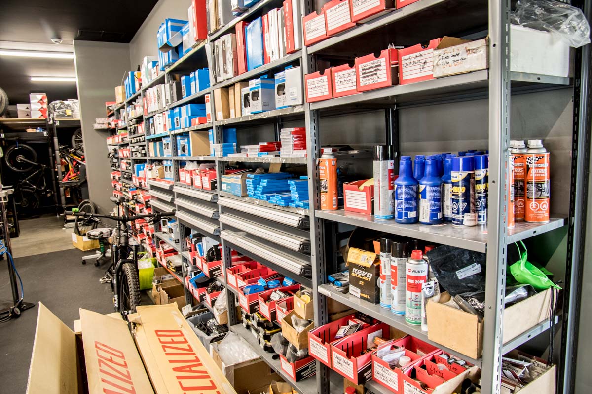 Metal shelves in an industrial warehouse with various maintenance products.