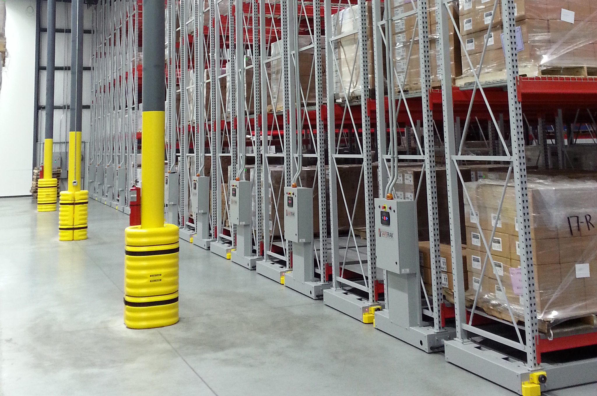 Montel mobile shelving system with pallets stored in a warehouse, equipped with control panels.