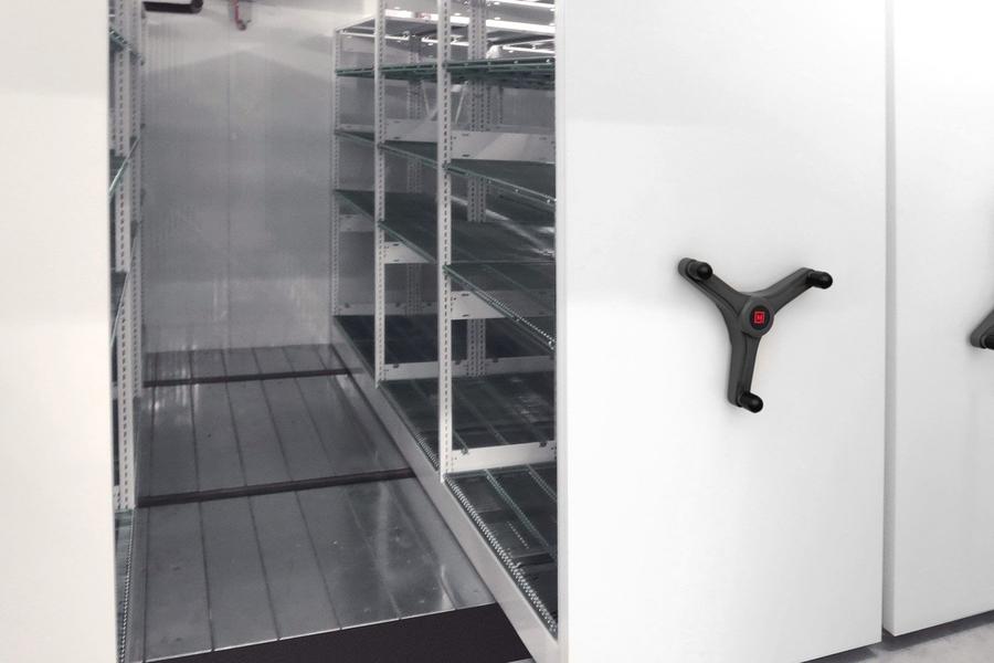 &#201;tag&#232;res en m&#233;tal vides avec une manivelle noire dans une chambre froide.