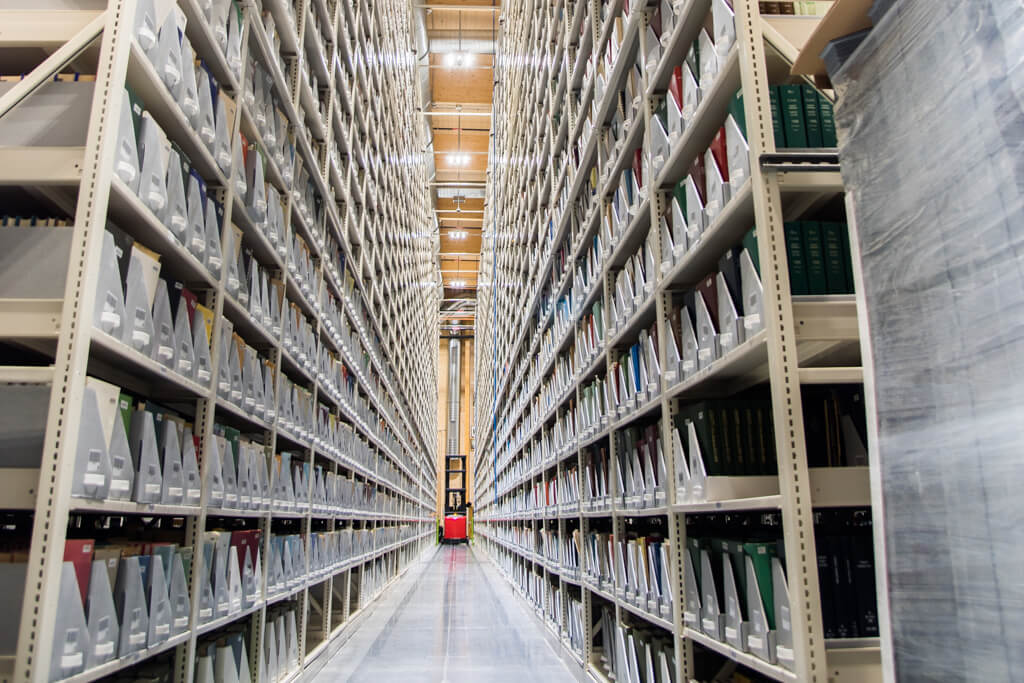 Vue en perspective d&#39;un couloir d&#39;&#233;tag&#232;res de stockage, avec des fichiers bien organis&#233;s des deux c&#244;t&#233;s.