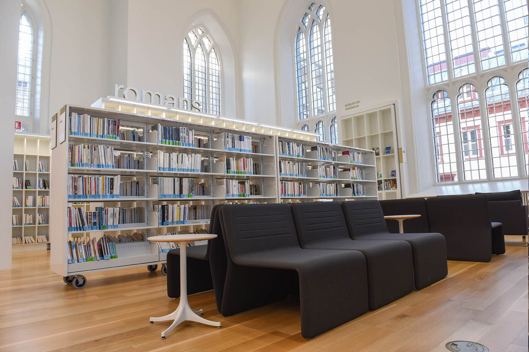 &#193;rea de lectura c&#243;moda con sof&#225; negro y estanter&#237;as de biblioteca.