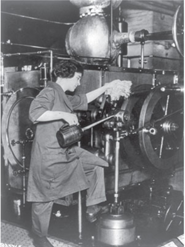 Mujer trabajando en una m&#225;quina industrial, limpiando y lubricando partes en una f&#225;brica.
