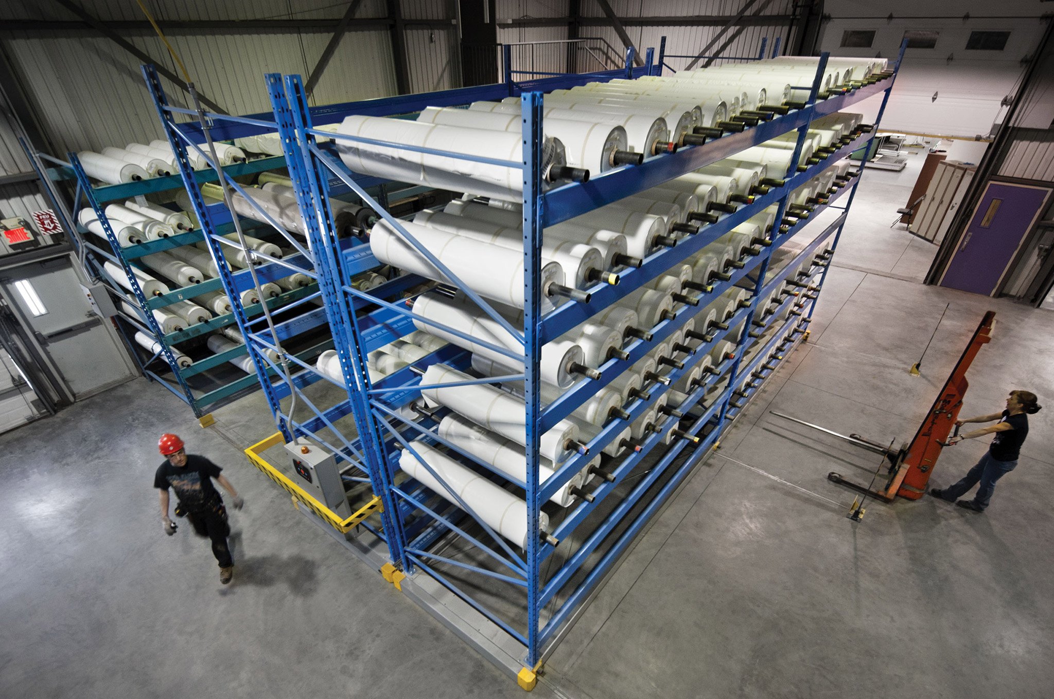 Blue Montel shelving system used for tube storage in a warehouse.